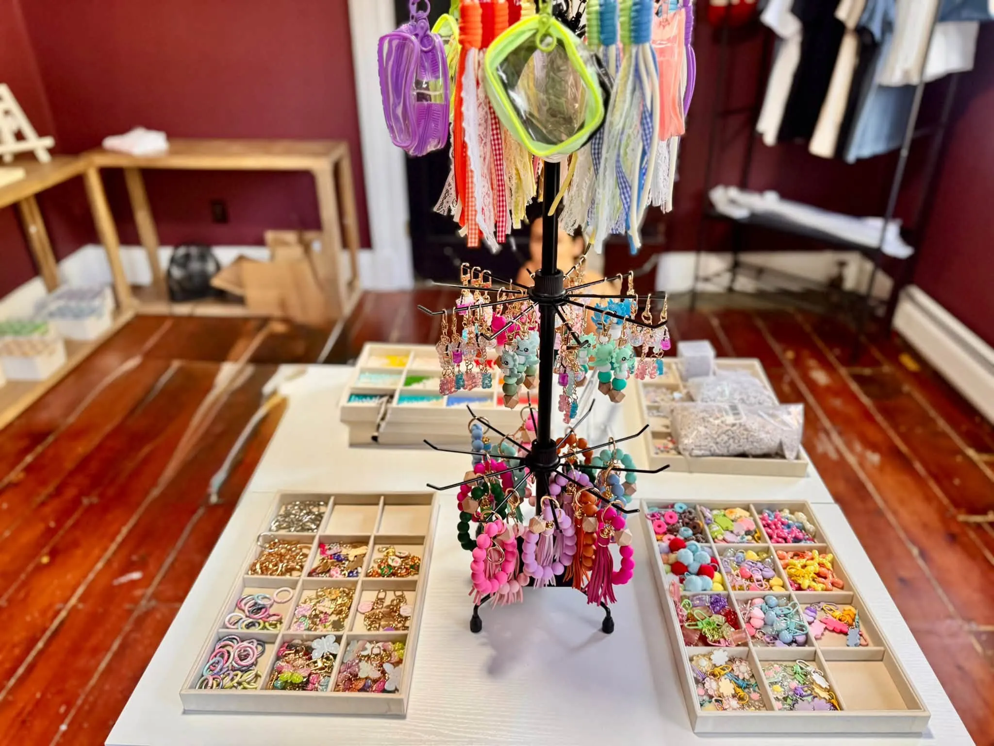 A craft table in the shop, laid out with beaded keychains, charms and jewellery-making trays